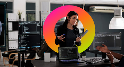 Two individuals are collaborating in a tech-savvy, modern office environment filled with computers