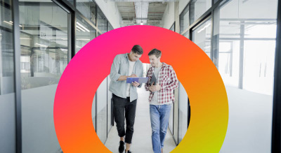 Two people walking through a doorway in a modern office building