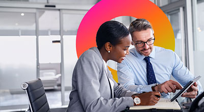 Two professionals are engaged in reviewing a document on a digital tablet