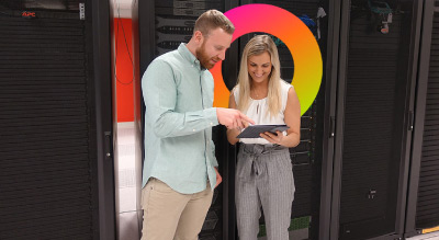Two employees standing in front of servers