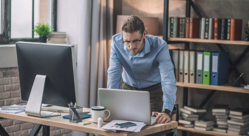 An employee working on a laptop in an office