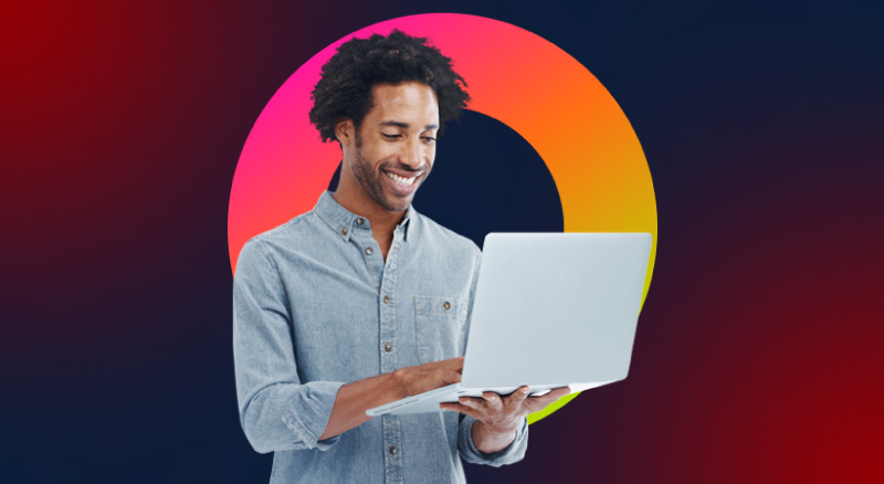 A cheerful individual typing on a laptop they're holding