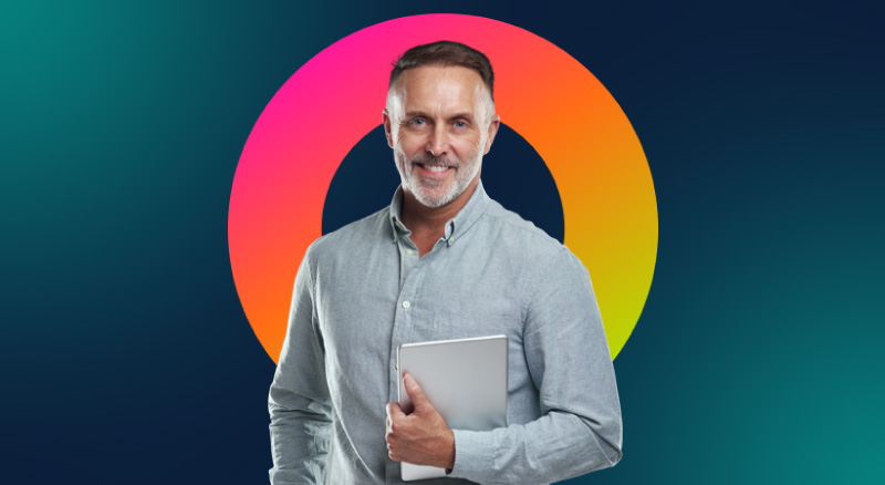 A smiling individual holding a closed laptop
