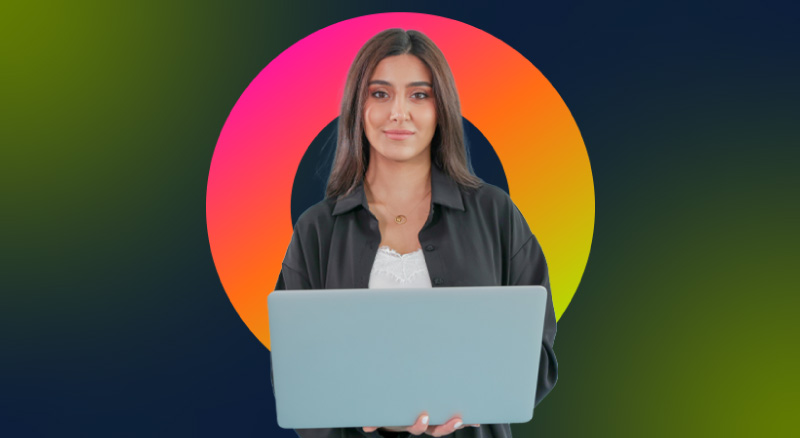 An individual standing while holding a laptop