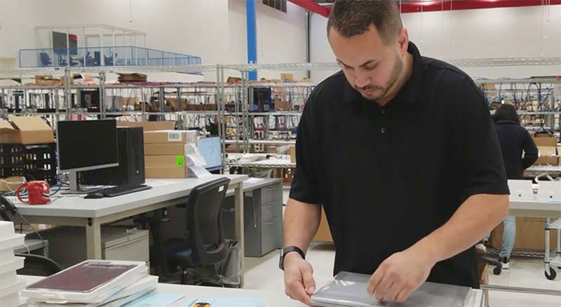 An employee unpacking supplies at an surrounded by office supplies