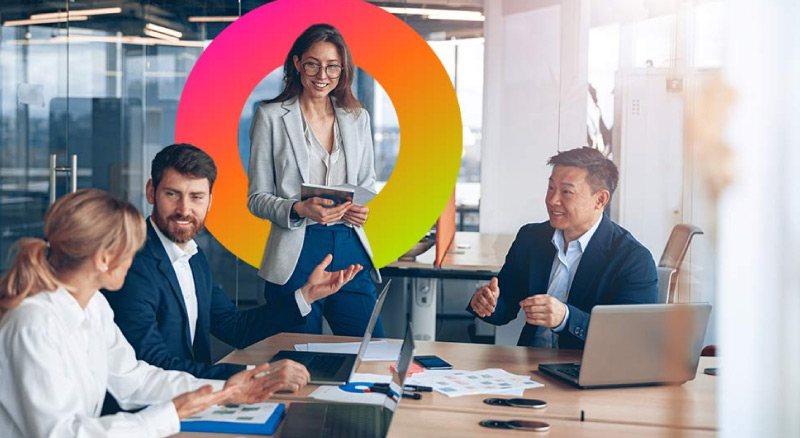 Employees huddle around table having discussion