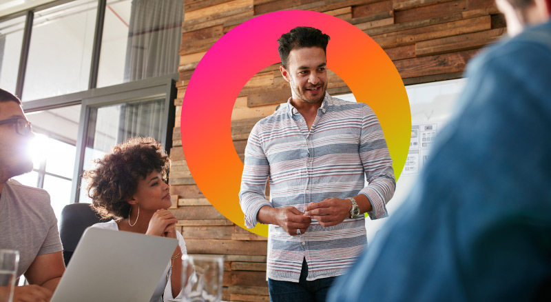 Man talking to workers sitting around table