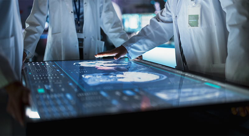 A group of doctors collaboratively examining a computer screen, engaged in discussion and analysis of medical data