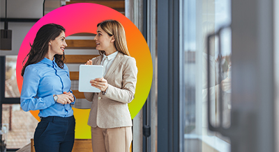 Two people in business attire stand confidently in an office setting showcasing professionalism and teamwork