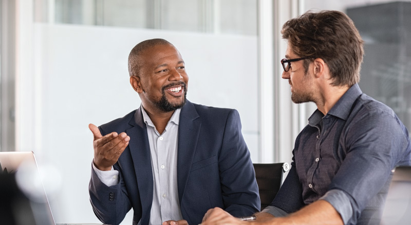 Two individuals engaged in a conversation in an office setting