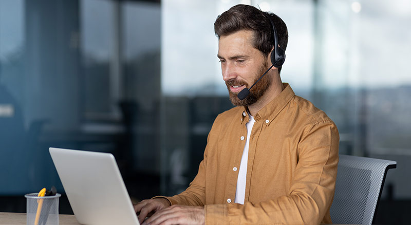 A customer service representative typing on a laptop