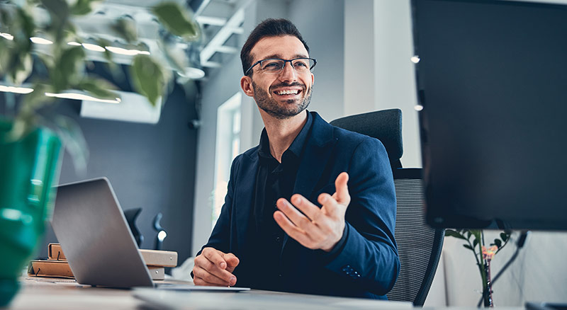 An employee smiling in an office helping customer maximize their servicenow investment