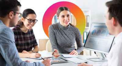 Four employees having a meeting in front of a monitor