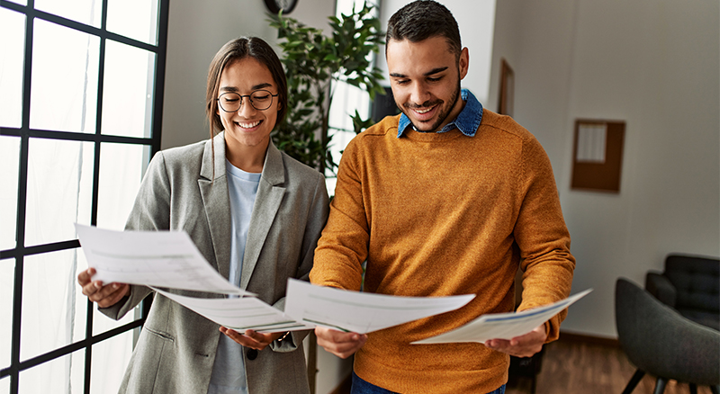 Two individuals discussing paperwork